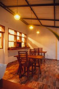 a group of wooden tables and chairs in a room at The Wild Side Cottage in Udawalawe +18 photos