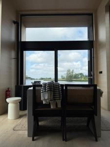 Zimmer mit einem Stuhl und einem großen Fenster in der Unterkunft Winter Getaway Houseboat Stay Romantic in Monnickendam