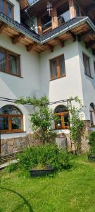 a white house with windows and a green yard at Pokoje gościnne Kamińscy in Gliczarów