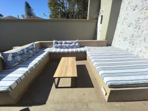 a large couch and a table on a patio at Bryanston Palms Accommodation in Johannesburg