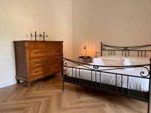 a bedroom with a bed and a wooden dresser at Kibilù - Casa Gaudia Natura, relax e comfort a due passi da Varese in Barasso