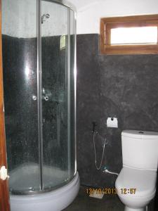 La salle de bains est pourvue d'une douche et de toilettes blanches. dans l'établissement cocoworld bungalow, à Bandara Koswatta