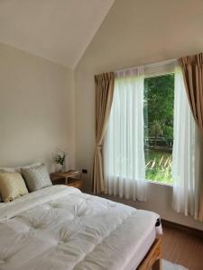 Un dormitorio con una cama y una ventana grande en Season to table, en Ban Cho Lae 11 fotos más