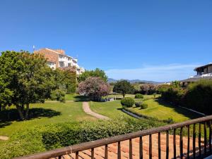 a view of a garden from a balcony at Capo Ceraso Family Resort in Costa Corallina