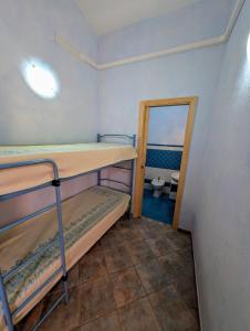 a small room with two bunk beds and a mirror at Capo Ceraso Family Resort in Costa Corallina