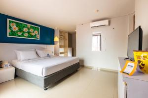 a bedroom with a large bed in a room at Kyriad Haka Makassar in Makassar