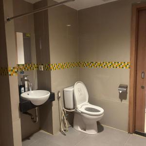a bathroom with a toilet and a sink at Kyriad Haka Makassar in Makassar +9 photos
