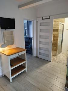 a living room with a table and a door at Apartament z klimatyzacją in Kąty Rybackie