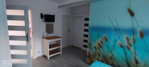 a room with a television and a room with a desk at Apartament z klimatyzacją in Kąty Rybackie +6 photos