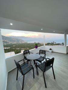 a table and chairs on a balcony with a view at Odore di Mare in Qeparo