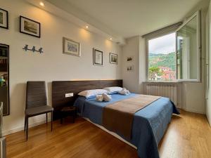 ein Schlafzimmer mit einem Bett, einem Stuhl und einem Fenster in der Unterkunft Evy’s Rooms in La Spezia