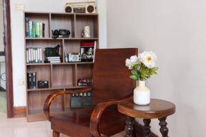 a vase of flowers on a table next to a chair at Rail & Rest Homestay - Railway View in Hanoi