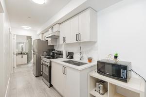 a kitchen with white cabinets and a microwave at Dumfries Guest Room in Vancouver in Vancouver