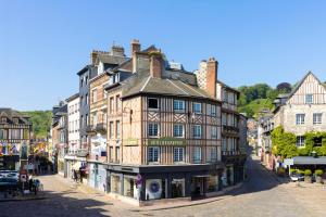 an old building in the middle of a street at Hotel Le Dauphin in Honfleur