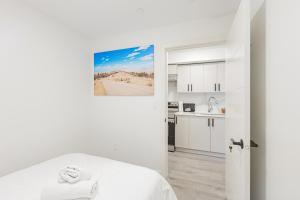 a white room with a bed and a kitchen at Dumfries Guest Room in Vancouver in Vancouver +15 photos