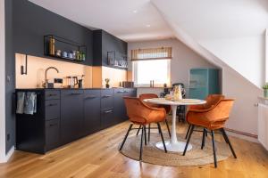 a kitchen with black cabinets and a table and chairs at Dachgeschoss ANNIE in Przyjezierze