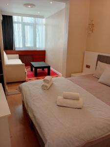 1 dormitorio con 2 toallas blancas en una cama en Karina Apart Hotel, en Estambul 5 fotos más