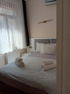 Un dormitorio con dos toallas en una cama con ventana. en Karina Apart Hotel, en Estambul