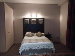 Un dormitorio con una cama grande con dos cuadros en la pared. en Urban City Kraal at Mapungubwe Hotel, en Johannesburgo 5 fotos más