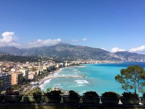 Blick auf einen Strand mit Gebäuden und das Meer in der Unterkunft Studio Mezzanine Bleu in Roquebrune-Cap-Martin