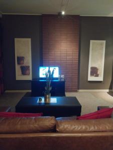 una sala de estar con un sofá y una mesa en Urban City Kraal at Mapungubwe Hotel, en Johannesburgo