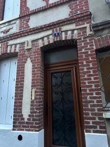 a brick building with a wooden door with a door at maison de pêcheur in Fécamp