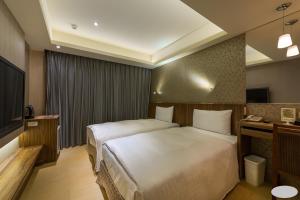 a hotel room with a bed and a television at Paris Business Hotel in Kaohsiung