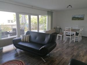 a living room with a black couch and a table at Monteurhaus GP in Kirchhain