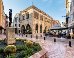 Un edificio con una statua in mezzo a una strada di Magnifique villa avec piscine a Perpignano