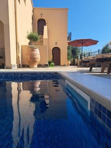 a villa with a swimming pool in front of a house at Boutique Hotel Caramel in Syvota