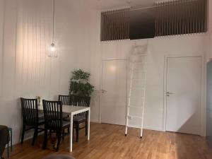 a dining room with a table and chairs and a ladder at Beautiful Apartment with a Loft in Lomma