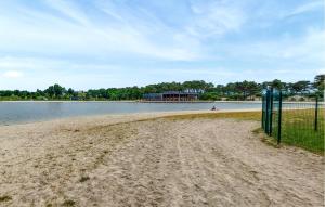 a beach with a fence next to a body of water at Jolie Maison Neuve in Casteljaloux +13 photos