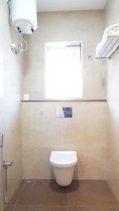 a bathroom with a toilet and a window at The Viva Grand in Chennai