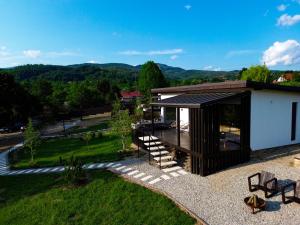 a small house with a roof with a staircase at Transalpina Tiny House - outdoor jacuzzi in Baia de Fier