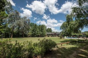 a large grass field with a house in the background at Quinta La Soñada in Etchegoyen