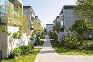 a walkway between two buildings with plants at 三亚海棠湾蔚蓝海湾公寓 in Sanya