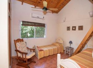 a bedroom with a bed and a chair and a window at Quinta La Soñada in Etchegoyen +28 photos