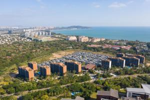 an aerial view of a city with buildings and the ocean at 三亚海棠湾蔚蓝海湾公寓 in Sanya