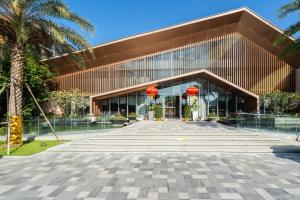 a building with red lanterns in front of it at 三亚海棠湾蔚蓝海湾公寓 in Sanya