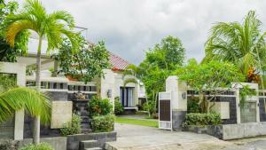 a house with palm trees in front of it at Puri Anturan Lovina in Lovina