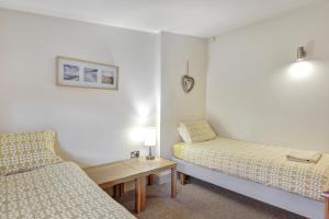 a small room with two beds and a table at Inglenook a Wandylaw Cottage, a cosy one too in Wandylaw