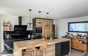 a kitchen with a large wooden island with two chairs at Cozy Home In Saint-Césaire-De-Gauzi in Saint-Césaire-de-Gauzignan