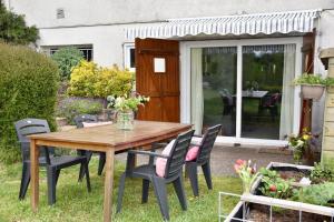 a wooden table and chairs in a garden at Chez Marjon a Morvan in Montigny-en-Morvan