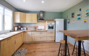 Una cocina con gabinetes de madera y un refrigerador blanco. en Maison Agréable Près Etretat, en Beaurepaire