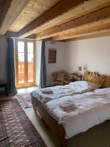 Un dormitorio con una cama grande y una ventana grande. en Chalet Tarine, en Bourg-Saint-Maurice