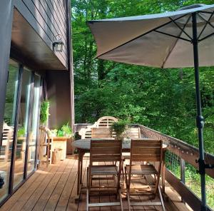 a patio with a table and chairs and an umbrella at Maison Tronchiennes in Durbuy