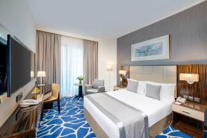 Rúm í herbergi á Hawthorn Extended Stay by Wyndham Abu Dhabi City Center