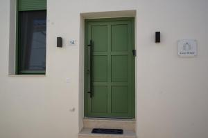 a green door on the side of a building at Casa di Keti - Modern Home with Private Yard ,3 Min to the Beach in Chania
