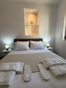 a bedroom with a large bed with two towels on it at Casa di Keti - Modern Home with Private Yard ,3 Min to the Beach in Chania