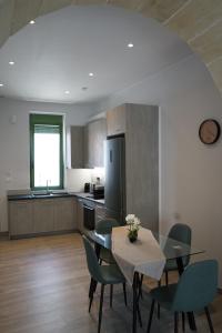 a kitchen with a table and chairs and a kitchen with a refrigerator at Casa di Keti - Modern Home with Private Yard ,3 Min to the Beach in Chania